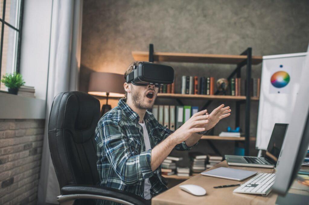 Emotional man playing a game using VR headset